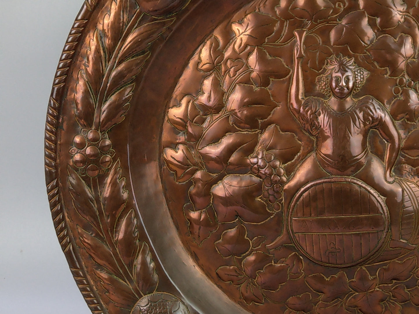 Large arts and crafts copper plaque Bacchus on the barrel with poppies wreath c.1900