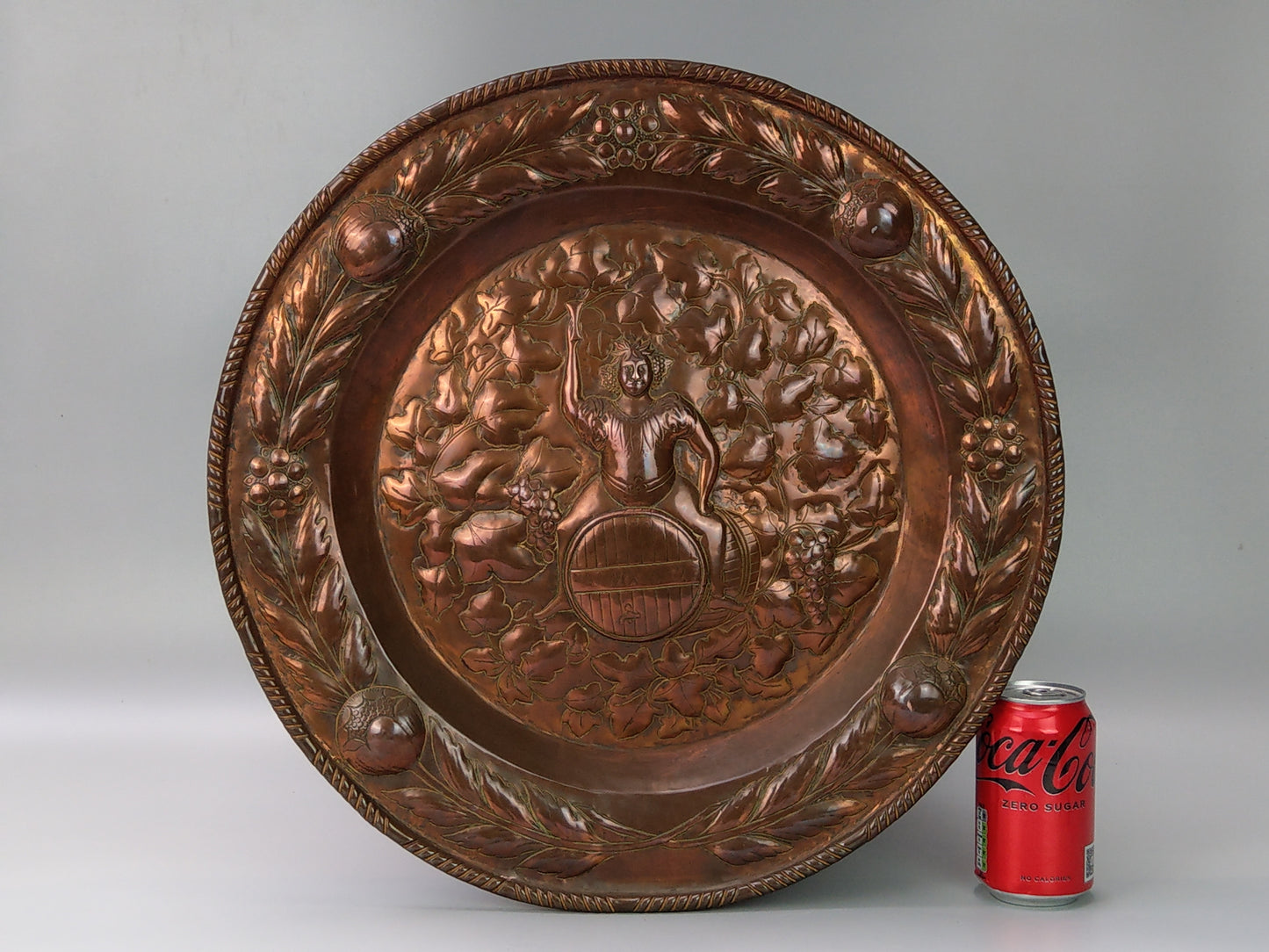 Large arts and crafts copper plaque Bacchus on the barrel with poppies wreath c.1900