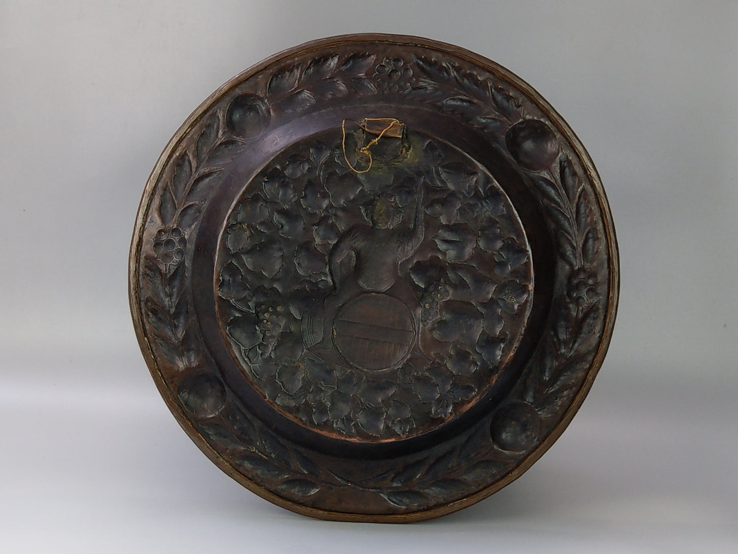 Large arts and crafts copper plaque Bacchus on the barrel with poppies wreath c.1900