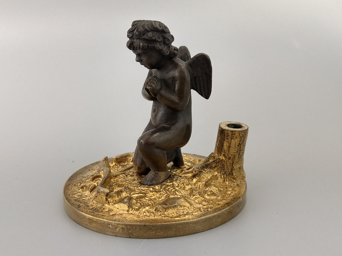 Antique Bronze Putto praying with a broken bow on a gold gild stand