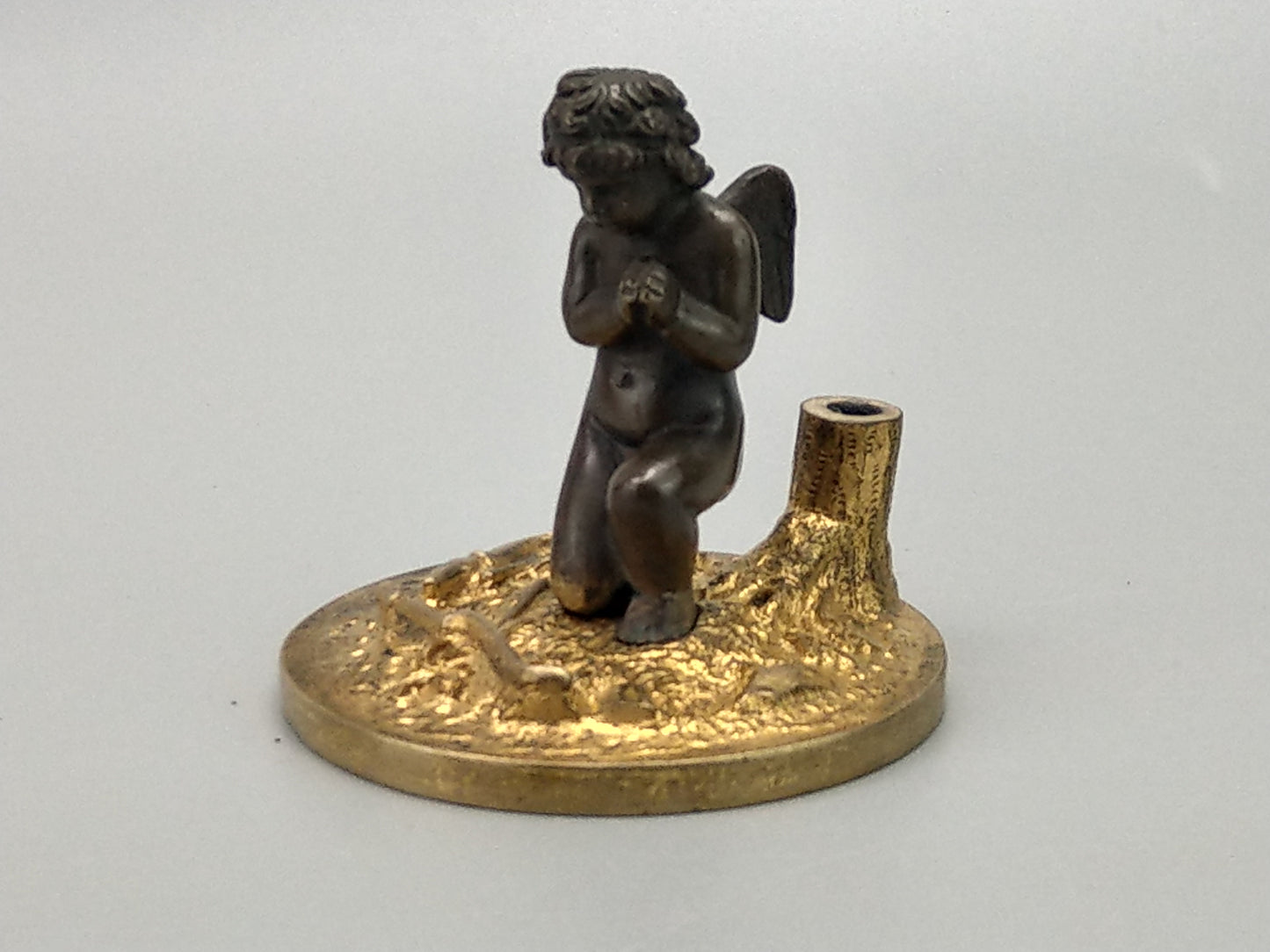 Antique Bronze Putto praying with a broken bow on a gold gild stand