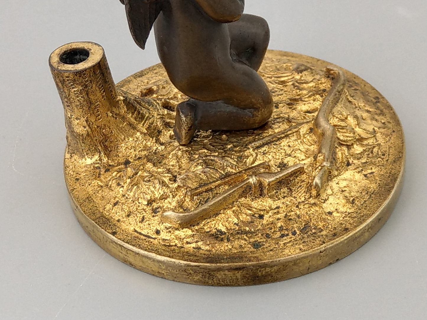 Antique Bronze Putto praying with a broken bow on a gold gild stand