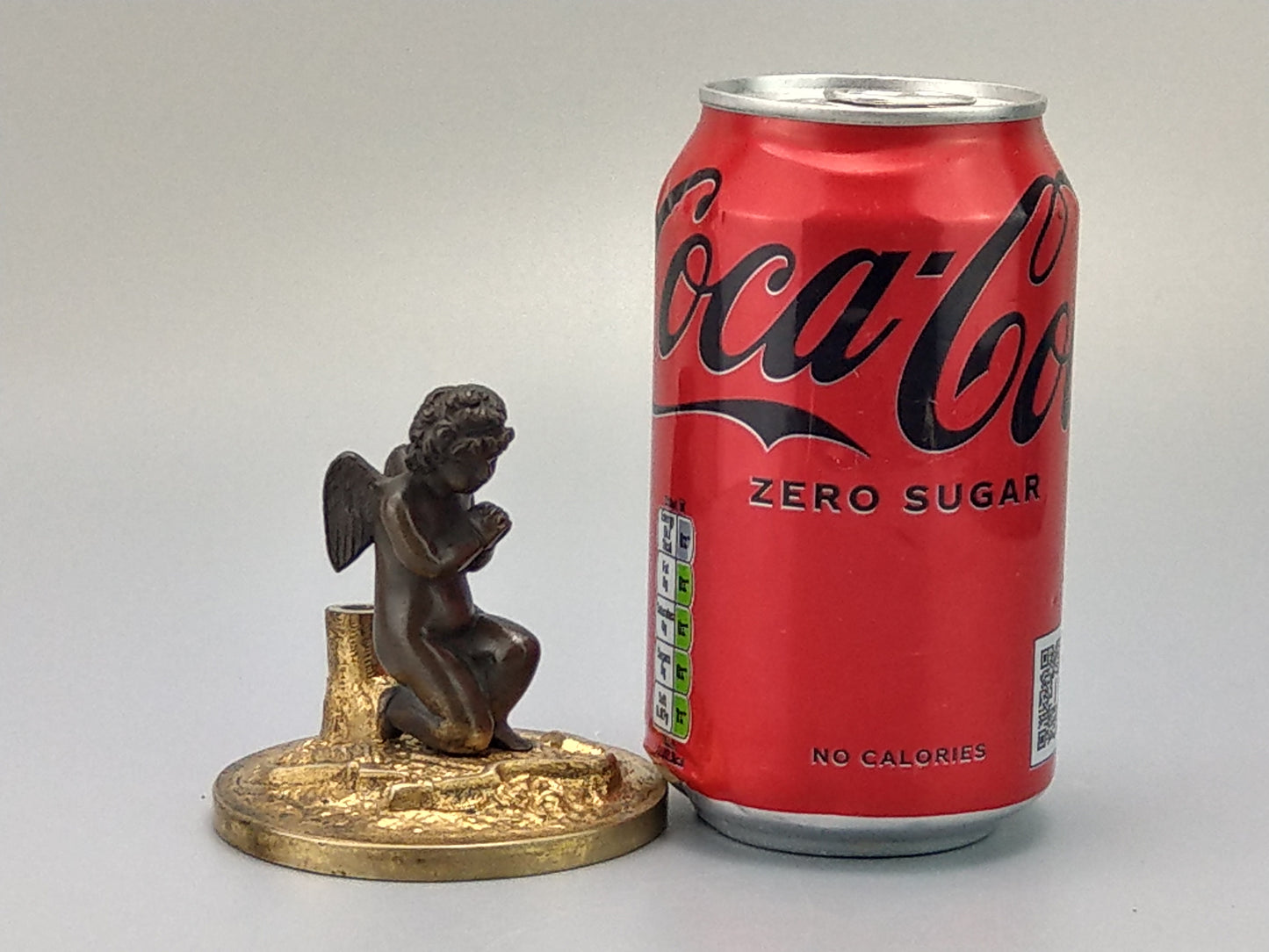 Antique Bronze Putto praying with a broken bow on a gold gild stand