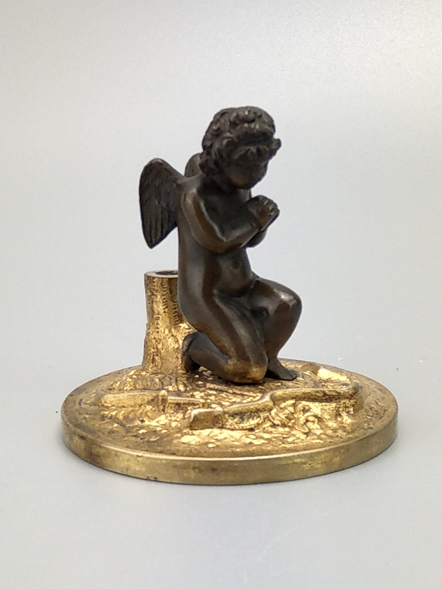 Antique Bronze Putto praying with a broken bow on a gold gild stand