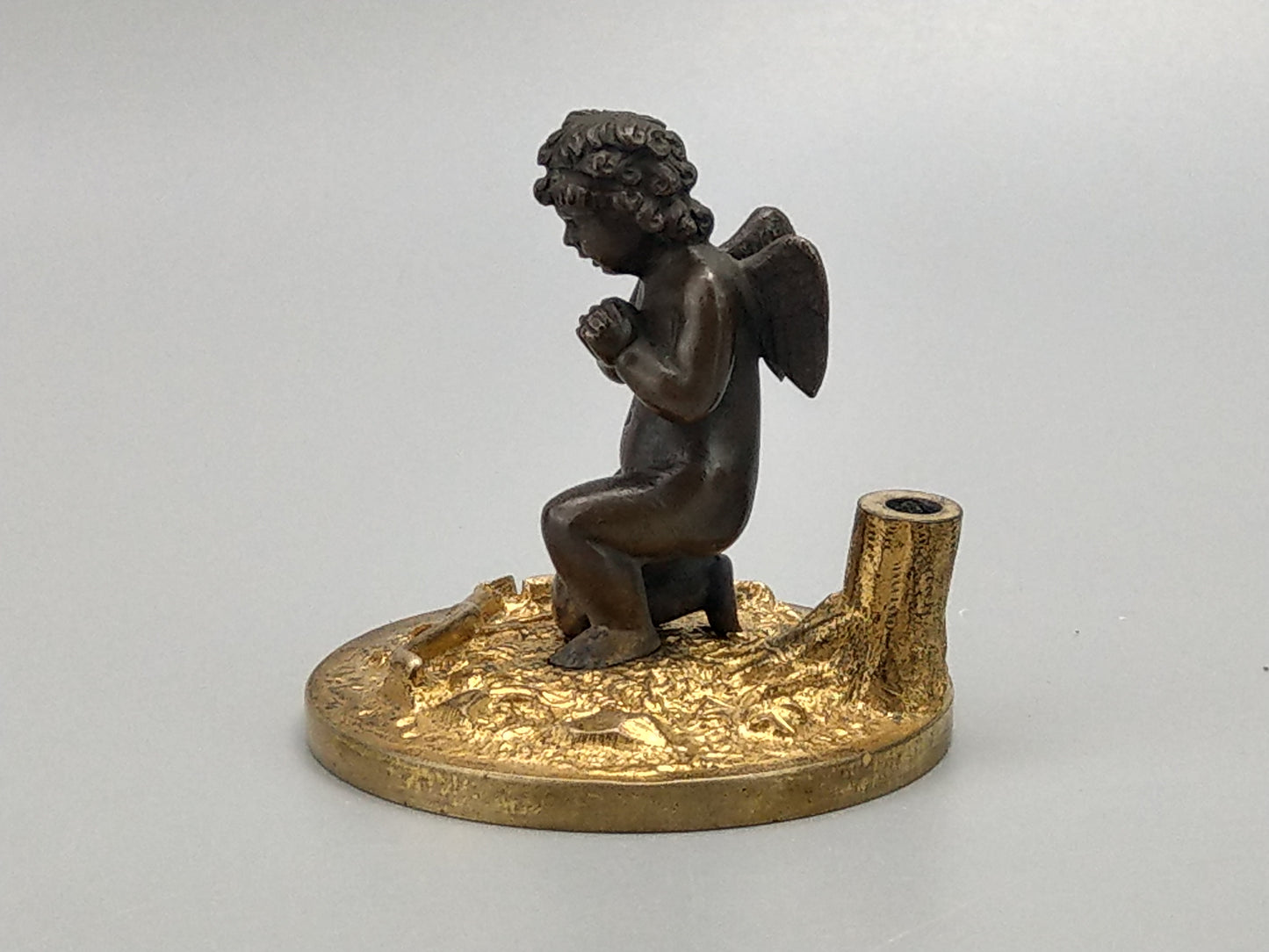 Antique Bronze Putto praying with a broken bow on a gold gild stand